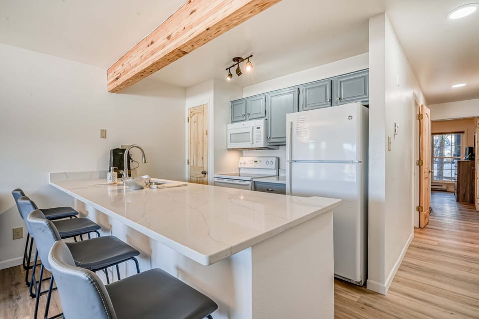 Cook in the full kitchen with a quartz breakfast bar and bar stools