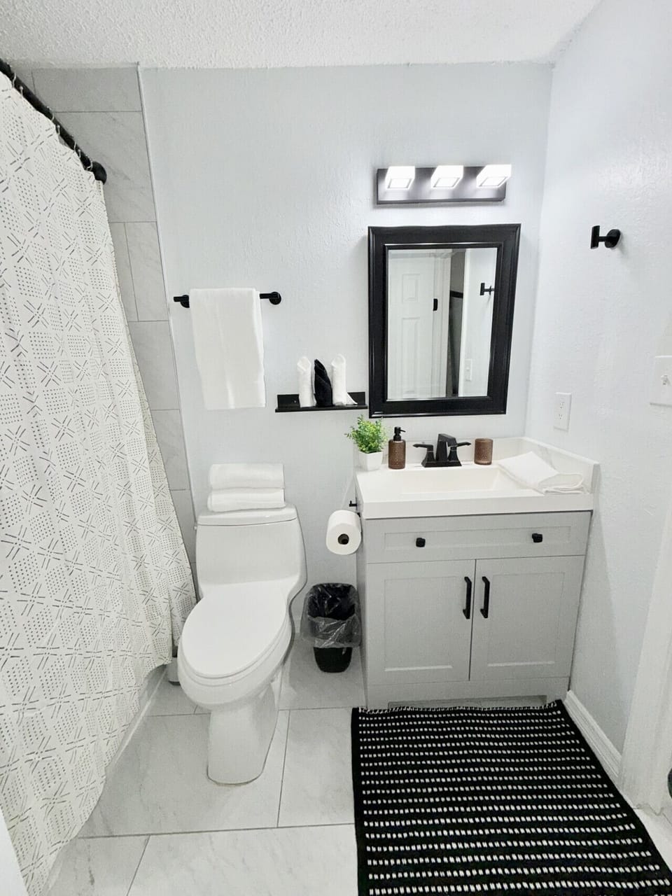 Clean, modern ensuite bathroom with fresh towels and a full tub/shower combo.