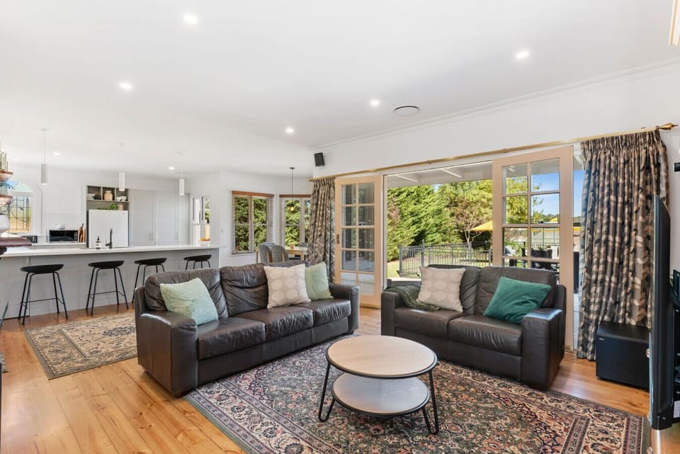 Inviting open living with leather sofas and garden access
