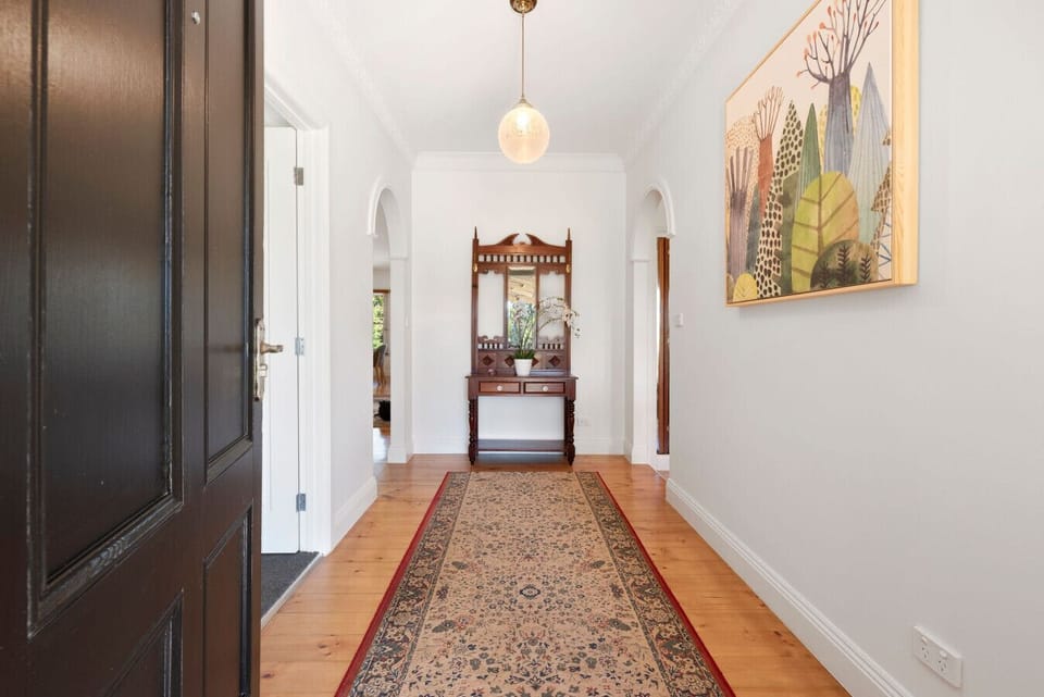 Charming heritage hallway with arches, Persian rug, and art