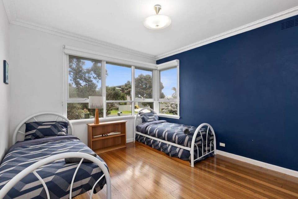 Bedroom 3: Cheerful twin bedroom with bold navy and bright windows