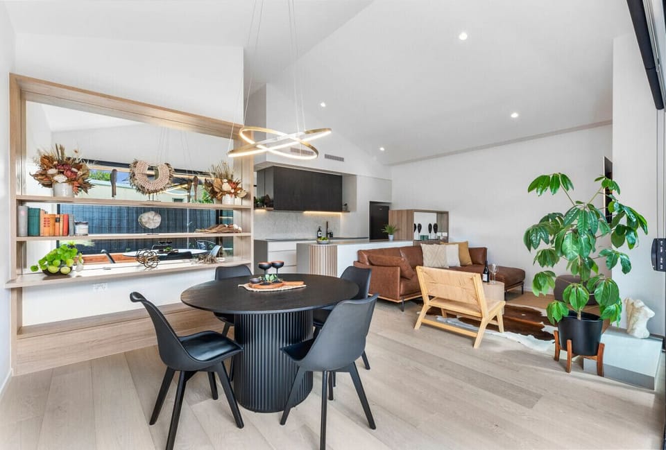 Stylish open-plan living with designer pendant light and shelving.