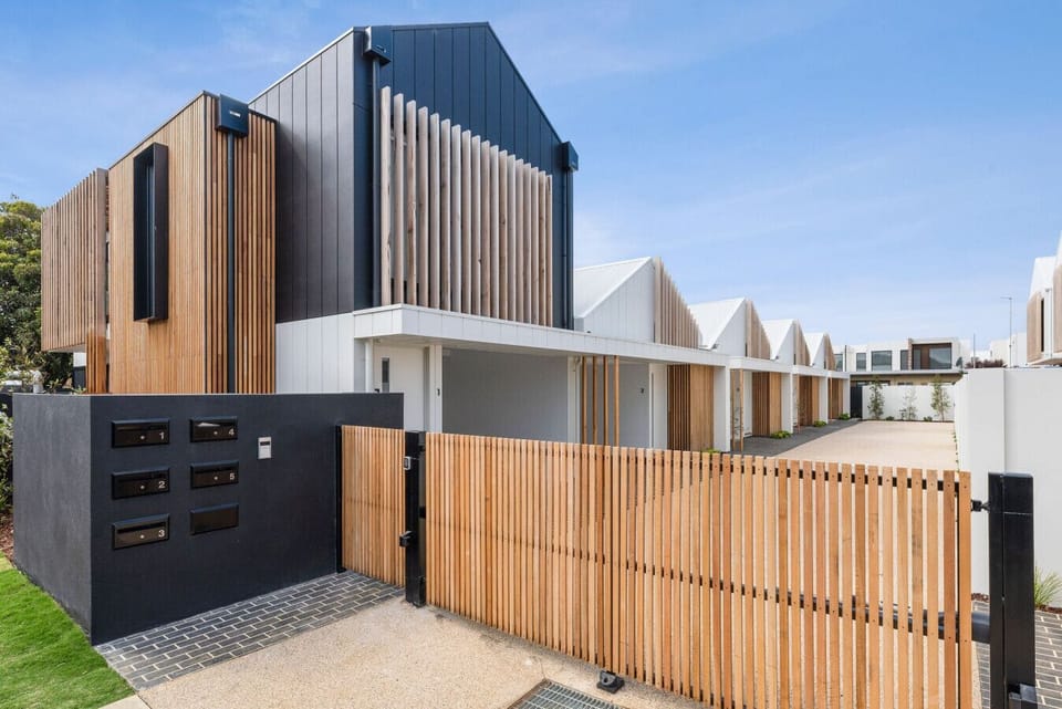 Striking contemporary townhouse with timber slat facade and secure gate.