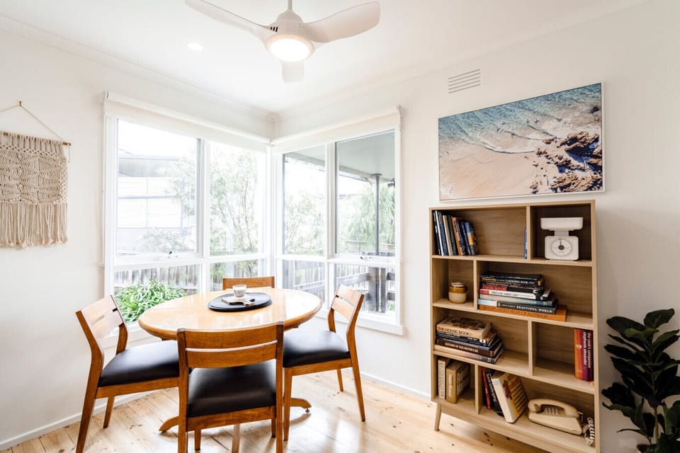 Sunny dining nook, round table, good books. Slow mornings welcome.