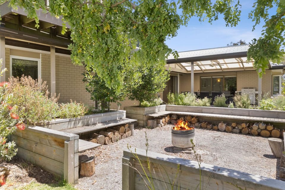 Lush garden courtyard with fire pit and raised garden beds.