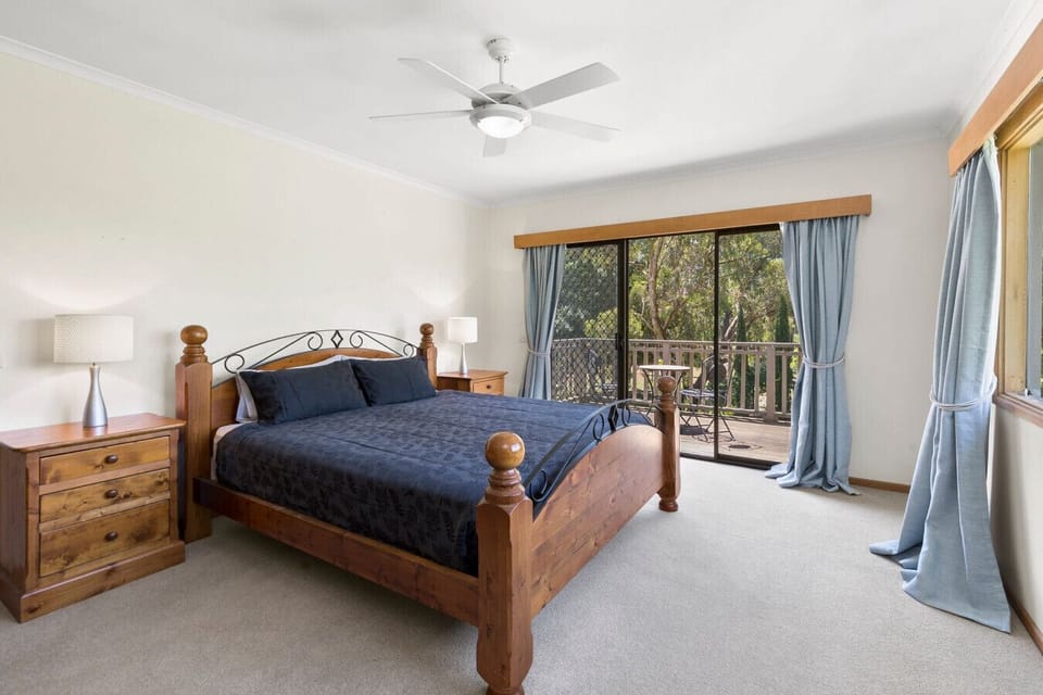Spacious master bedroom with balcony access and garden views.