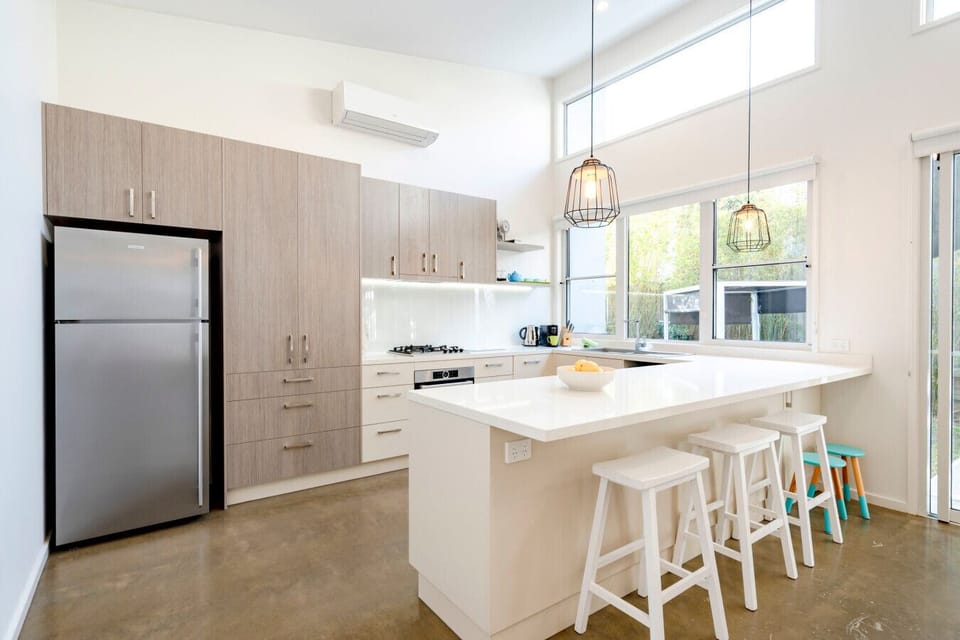 Well-equipped kitchen with island, fridge, and great natural light.