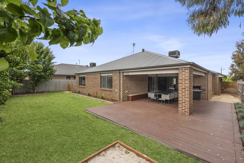 Private backyard with spacious deck, outdoor dining area, and BBQ setup