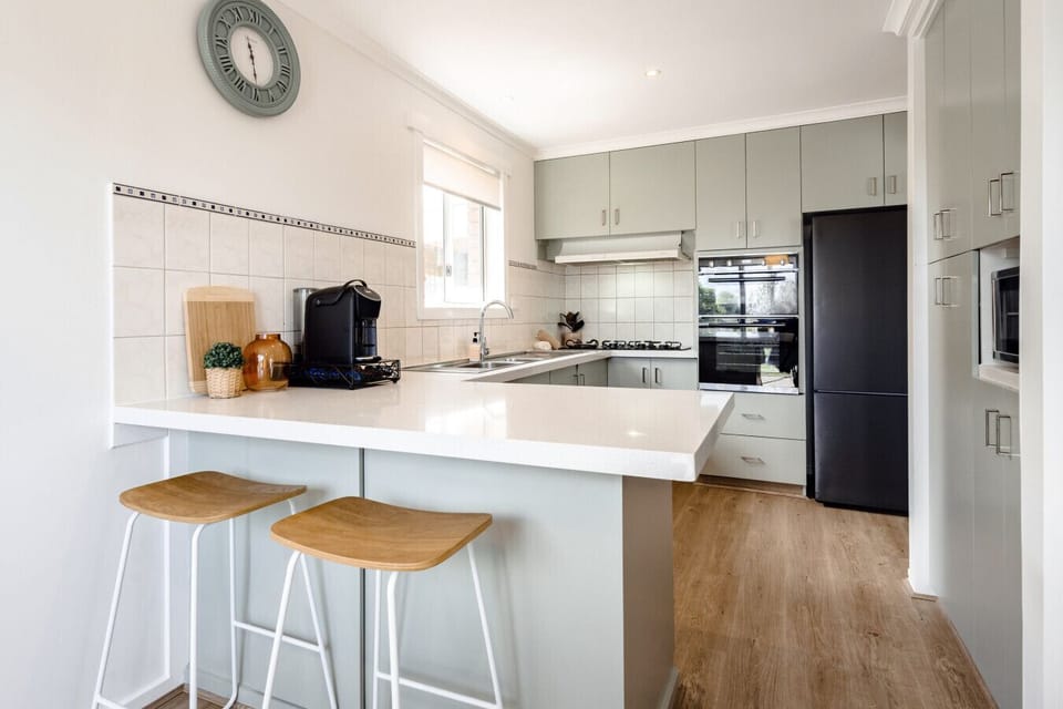 Modern kitchen with breakfast bar seating and sleek appliances.