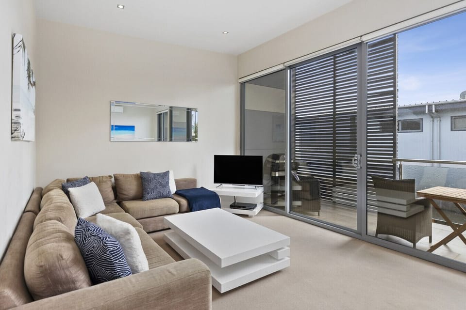 Bright living area with comfortable seating and direct access to a private balcony.