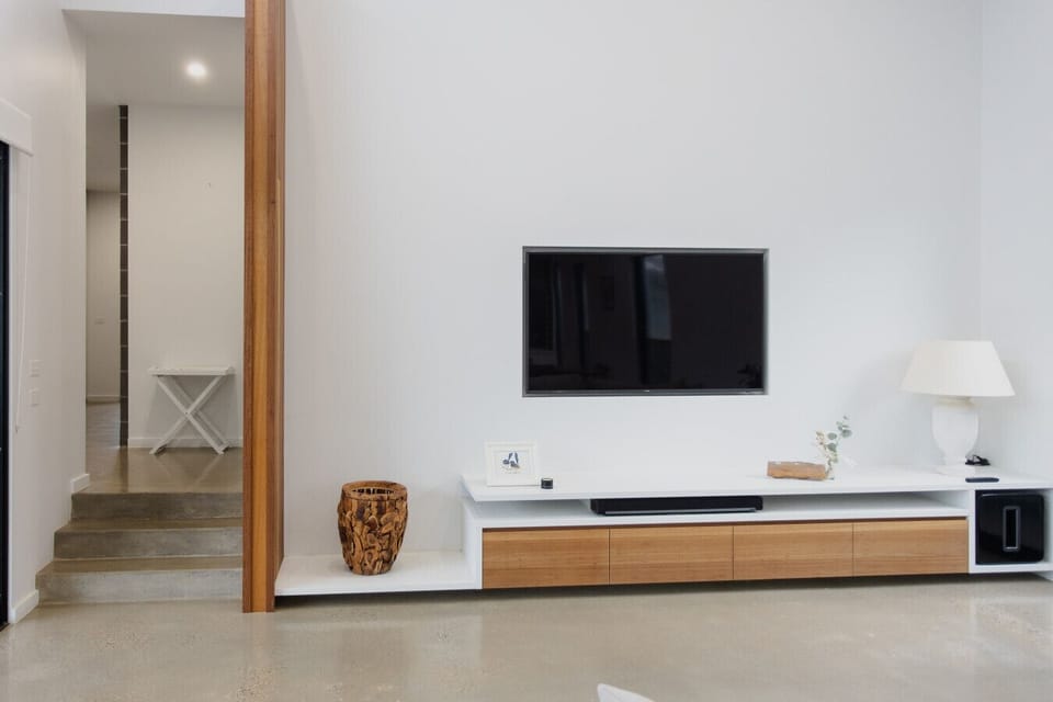 Large flat-screen TV with Sonos soundbar and a floating timber media unit — great for movie nights in.