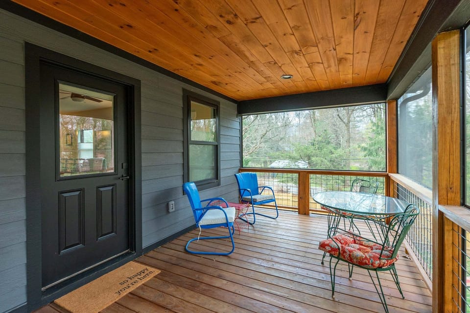 Screened-in back porch with a variety of seating.