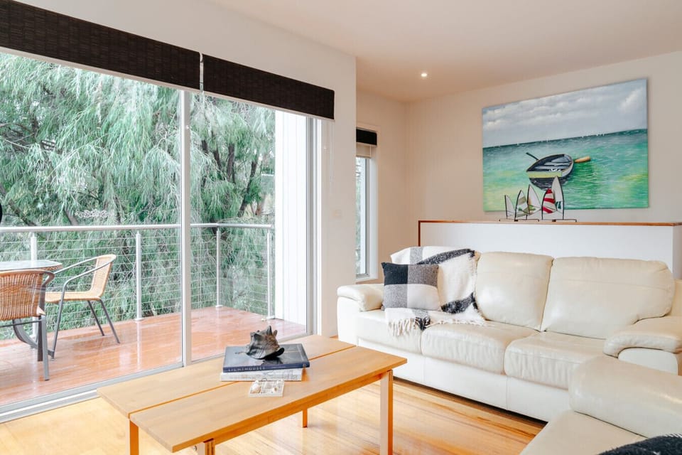 Bright coastal living room opening to a lovely balcony