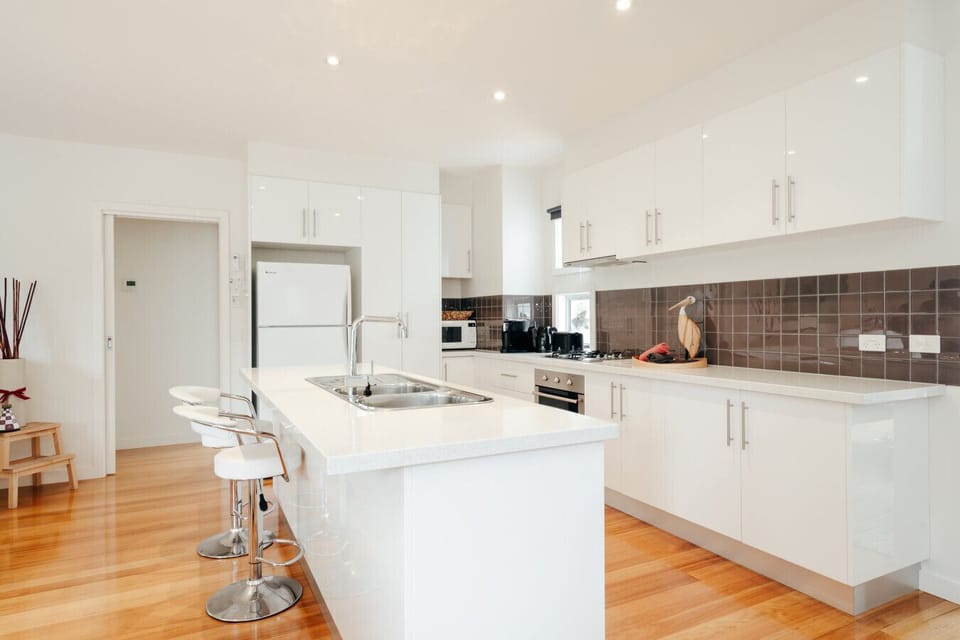 Spotless white kitchen with a generous island bench