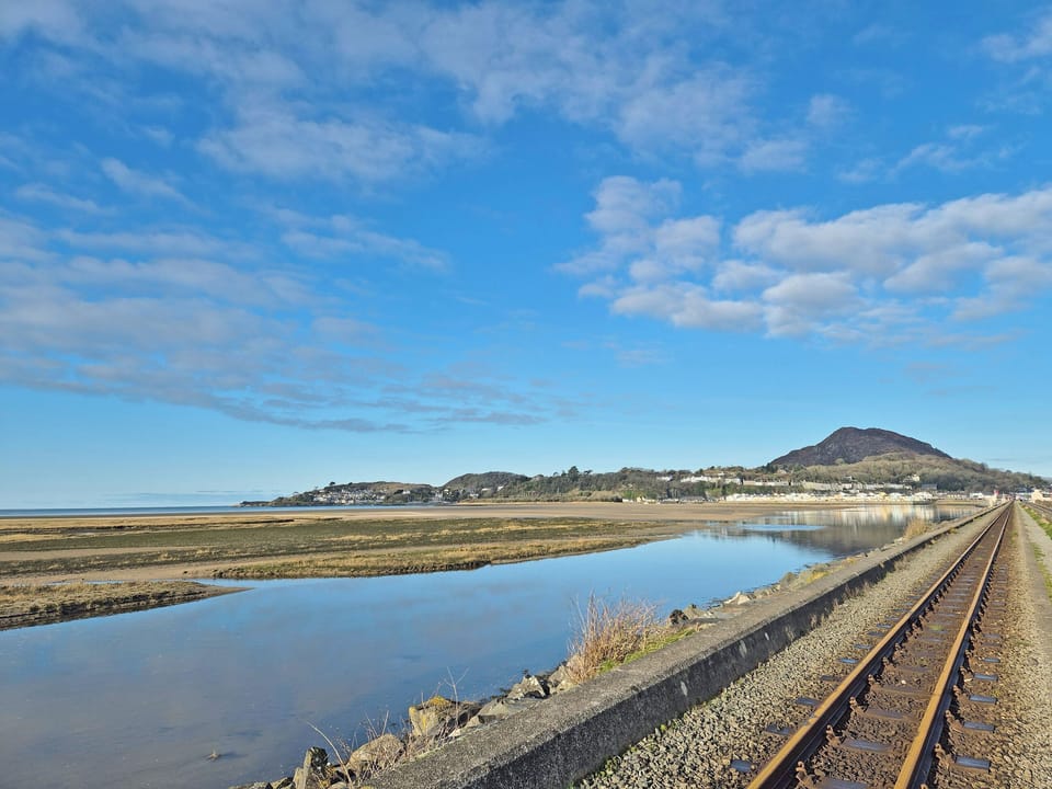 View of the flat below the saddle of Moel Y Gest and the shore from the Harbour Town of Porthmadog | The View Snowdon Wharf, Porthmadog