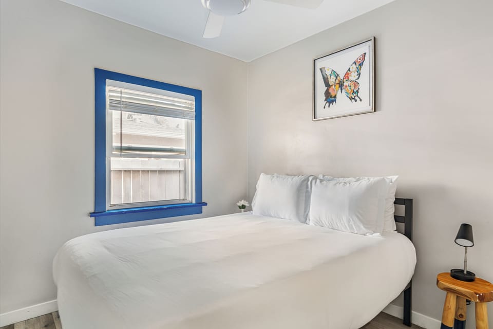 Primary bedroom with a plush queen bed and a serene atmosphere. (Main House)