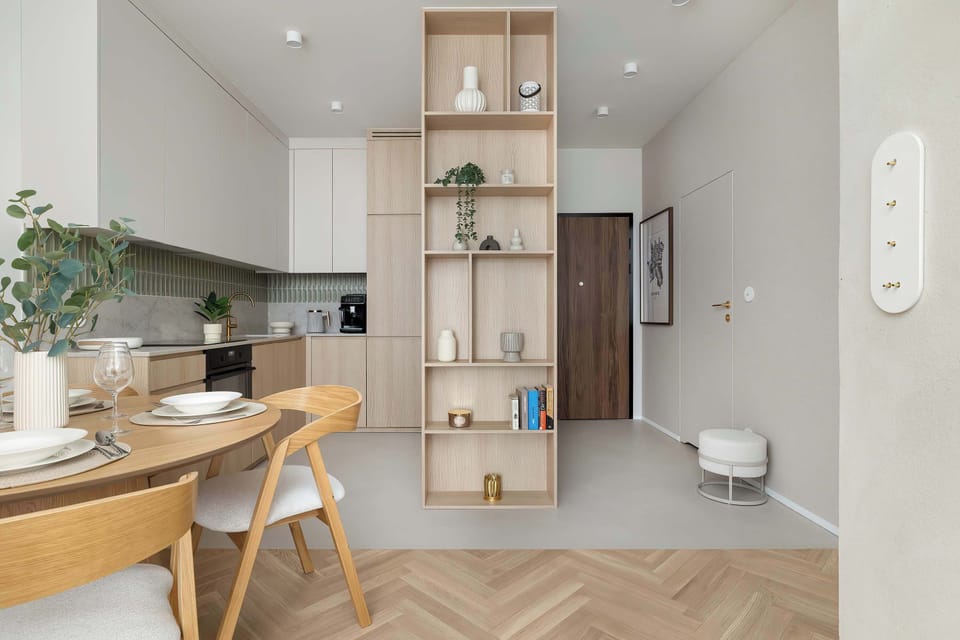 A kitchenette and hallway view shows the seamless transition from the cooking area to the rest of the home. The clean lines of the handleless cabinetry maintain a streamlined appearance.