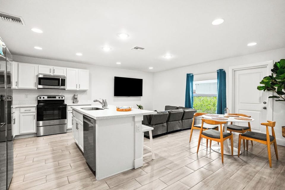 🛋️ Unwind in the inviting living room with a comfortable couch and a big flat-screen smart TV, all open to the kitchen. 🍿