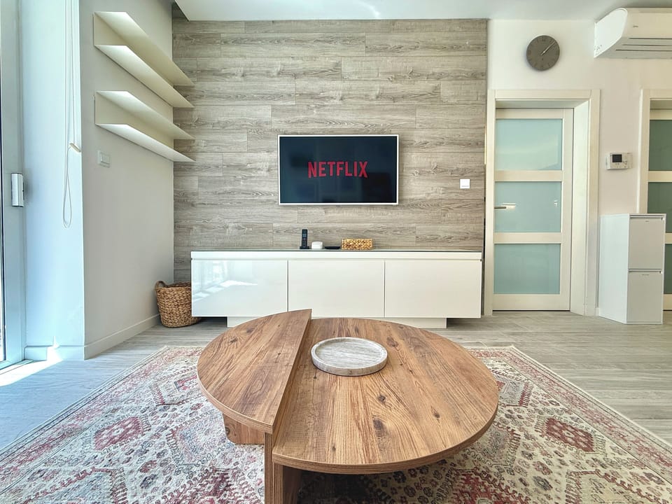 Living area equipped with a sofa bed, a flat-screen Cable TV for entertainment and a balcony.