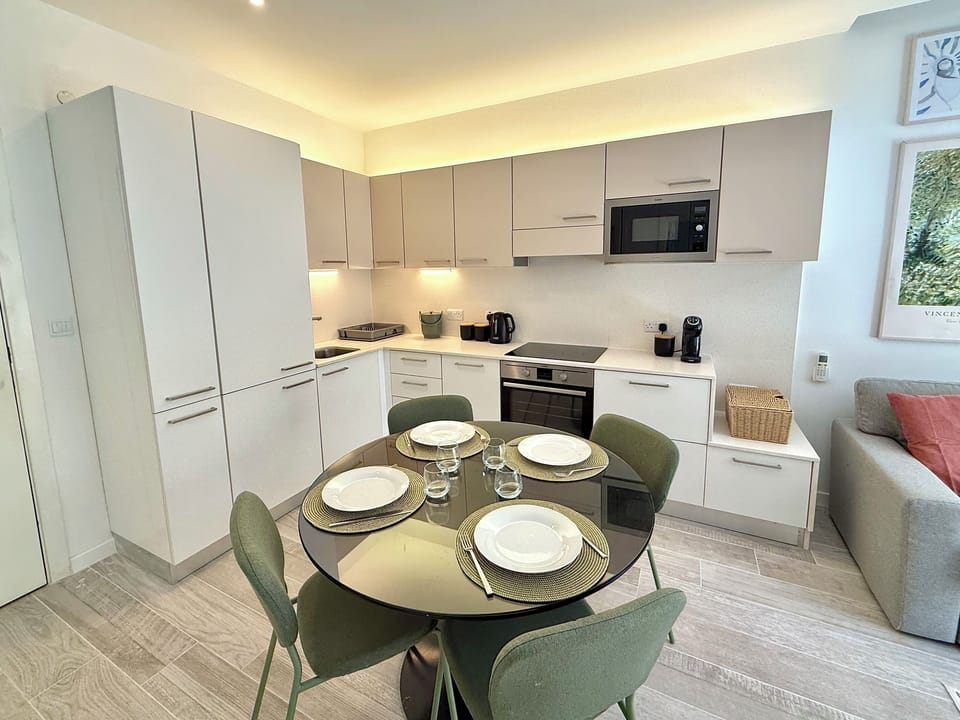 Kitchen area equipped with a refrigerator, electric cooker, oven, kettle, toaster, coffee machine, dishwasher and microwave.