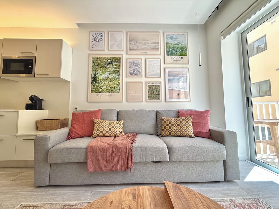 Living area equipped with a sofa bed, a flat-screen Cable TV for entertainment and a balcony.