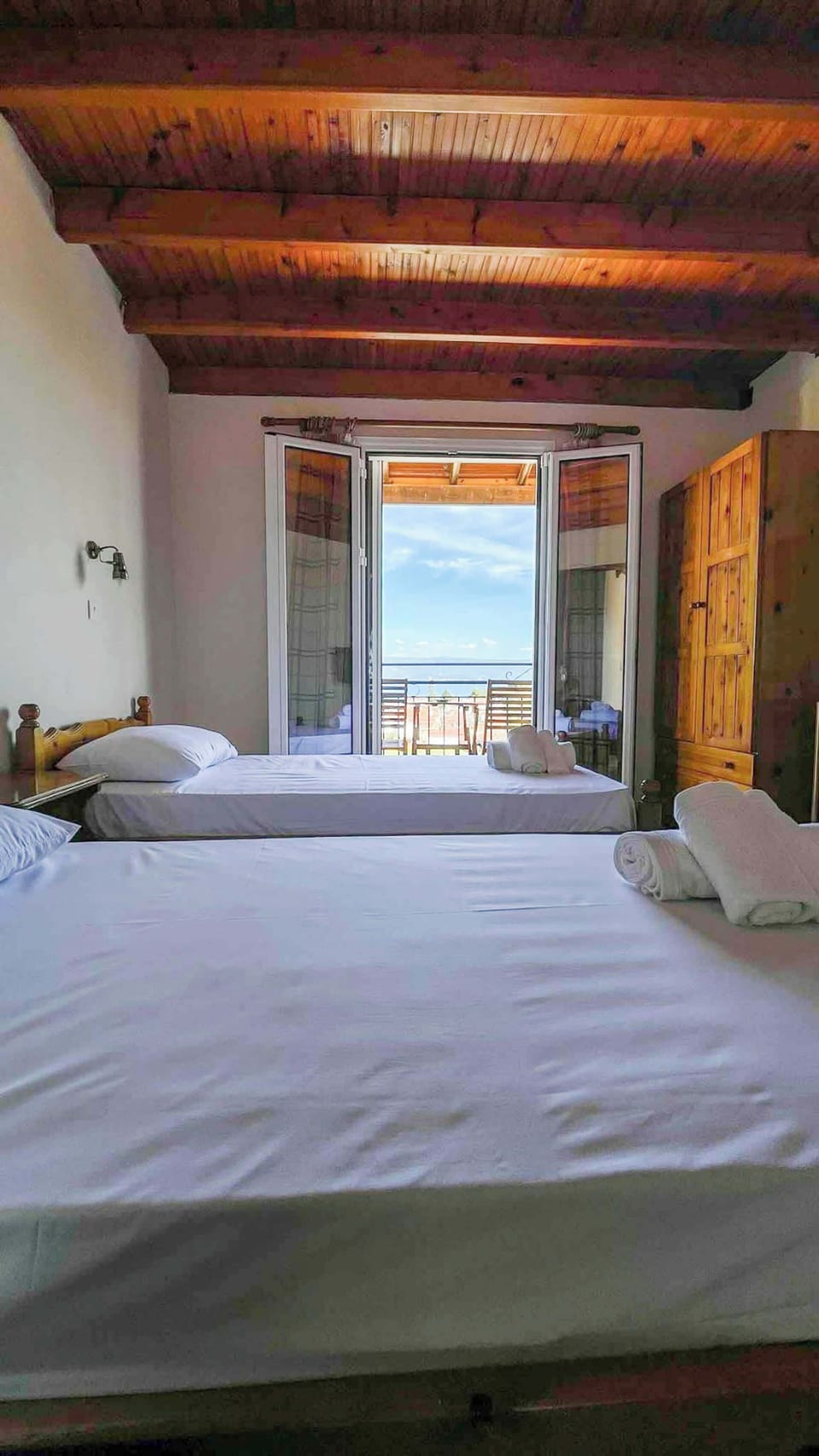 Spacious bedroom with wooden ceiling and balcony access