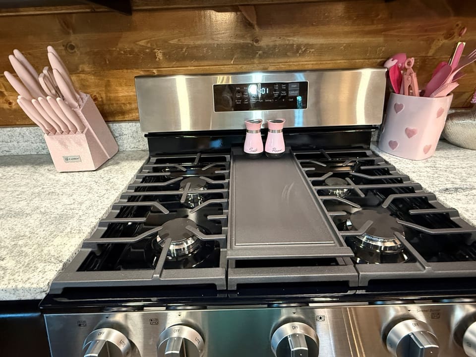 Your gourmet kitchen awaits with a professional-grade gas stove, granite counters, and charming accents—perfect for preparing hearty meals during your mountain getaway.