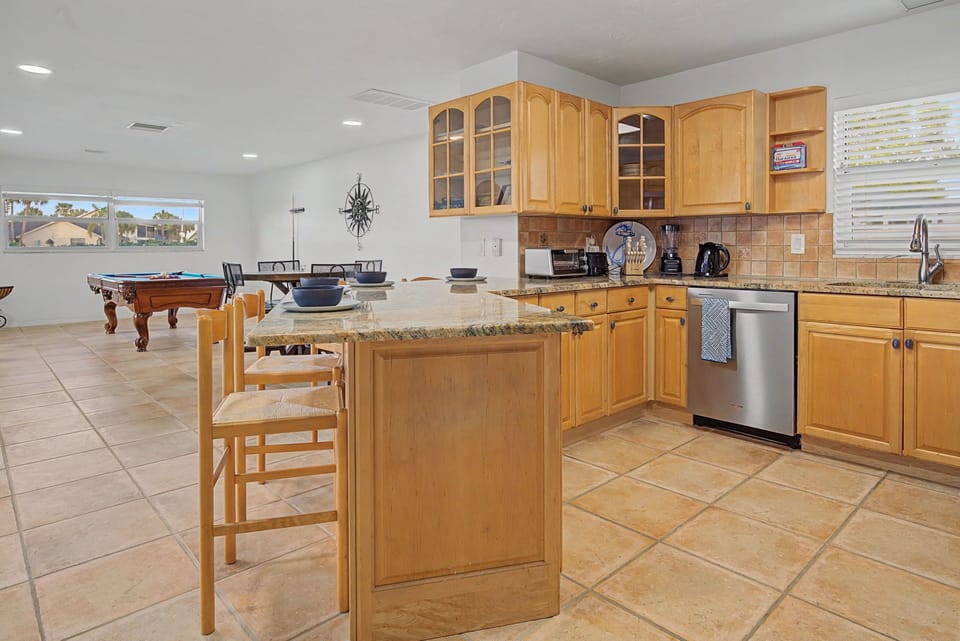 Your spacious kitchen island awaits with granite counters and warm wood cabinets, while the pool table promises endless entertainment nearby.