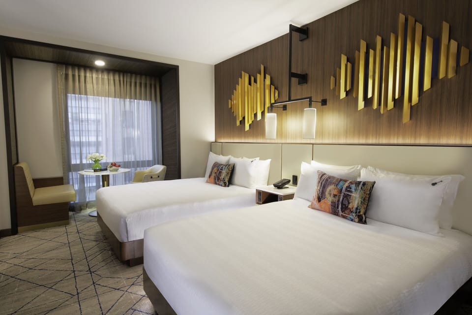 Unwind in a bright double-queen room with cozy seating nook.