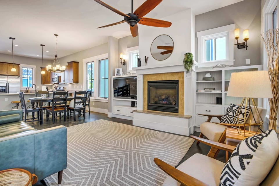 The open-concept main level was made for gathering, where the warmth of a gas fireplace, custom built-ins, and a herringbone rug pull you in the moment you walk through the door, with the kitchen and dining just beyond.
