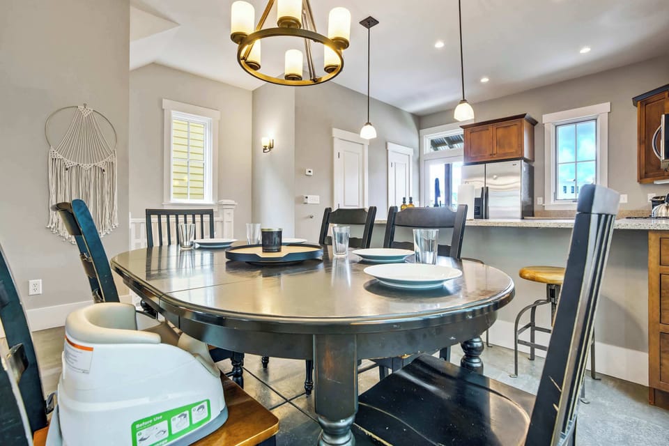 The warm glow of the gold-tone chandelier draws you into the dining space, where a handwoven wall piece adds mountain character and the kitchen flows naturally just beyond, keeping the whole main level connected.