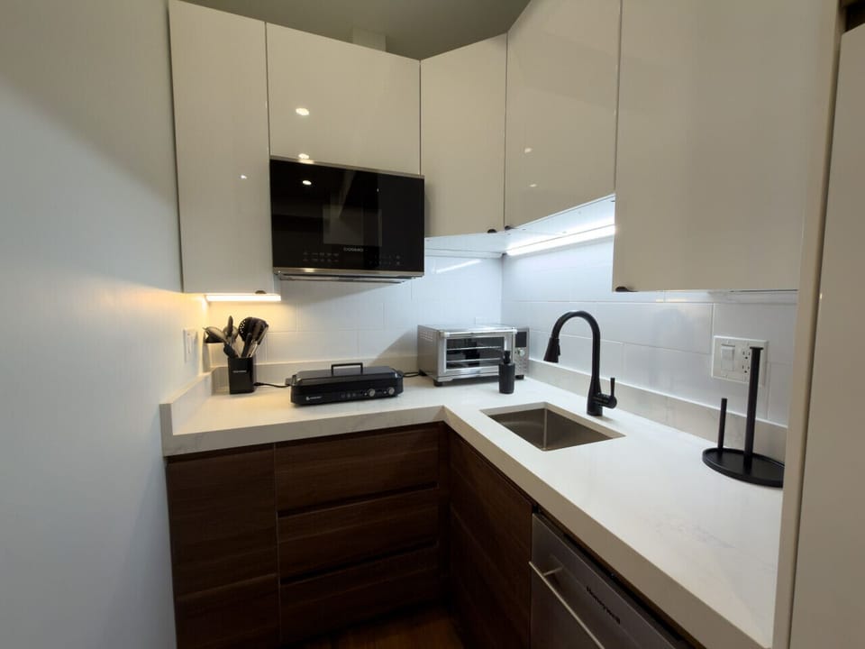 Fully equipped contemporary kitchen featuring stylish cabinetry and essential appliances.