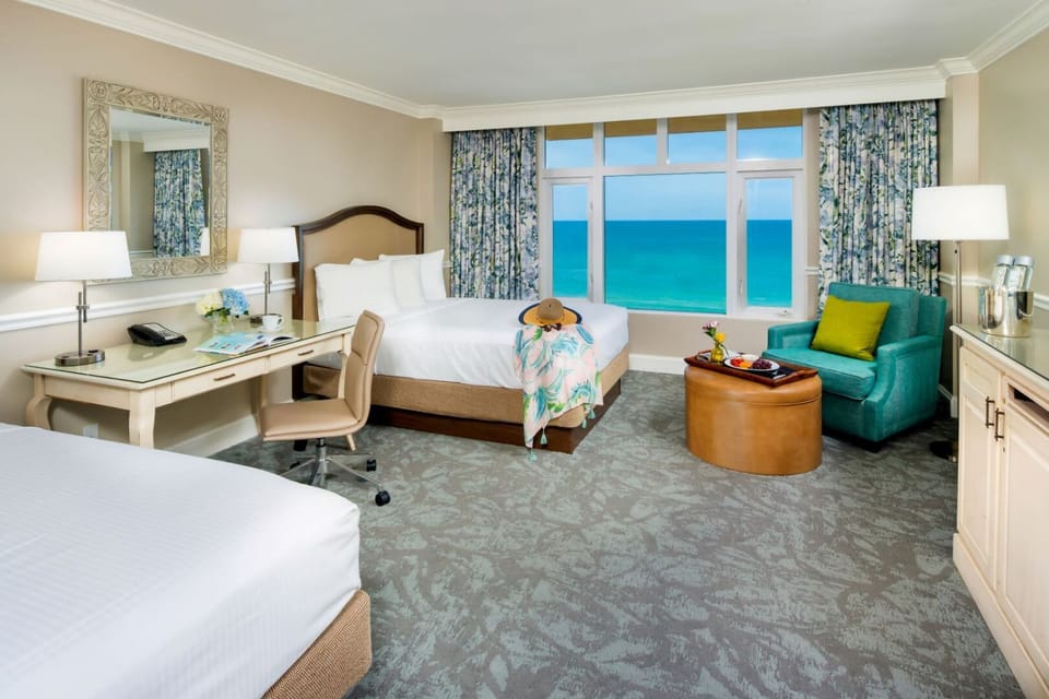 Settle into plush beds with calming sea-view backdrop.