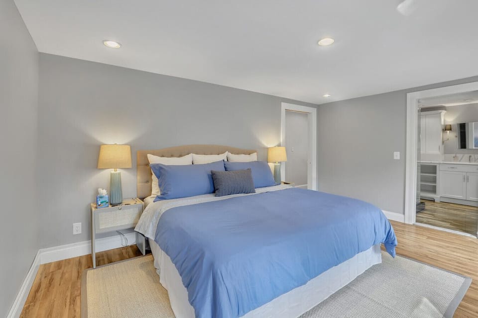 Relax in this serene primary suite featuring a plush king bed, calming tones, and a private ensuite bath