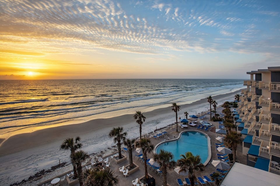 Soak in sunset magic beside the beachfront pool and palms.