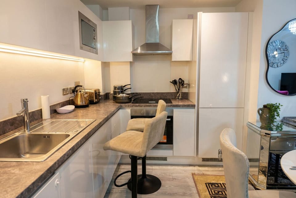 Under-cabinet mood lighting and a breakfast bar make morning coffee feel like a boutique hotel ritual.