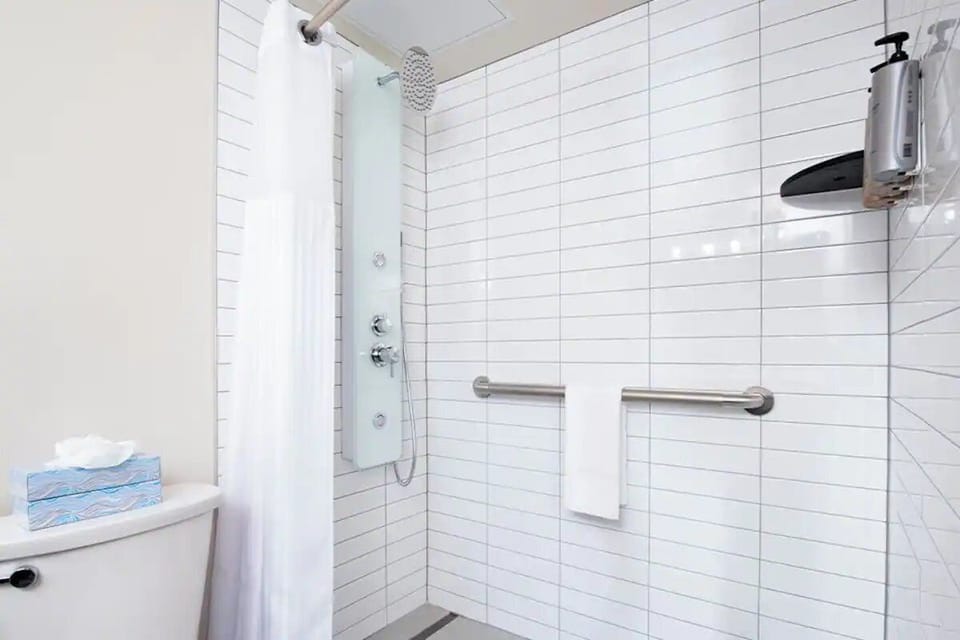 Refresh under a spa-style rainfall shower with grab bars.