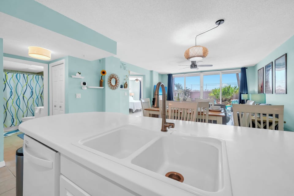 Your bright kitchen flows seamlessly into the dining area, where soothing sea-glass walls and natural light create the perfect space for morning coffee.