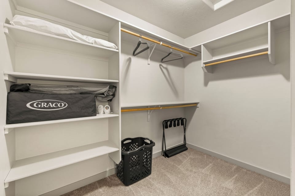 Spacious primary suite closet thoughtfully stocked with baby essentials, including a Pack ’n Play, monitor, extra pillows, and a luggage rack, making this family-friendly property fully equipped for comfortable, stress-free stays with little ones.