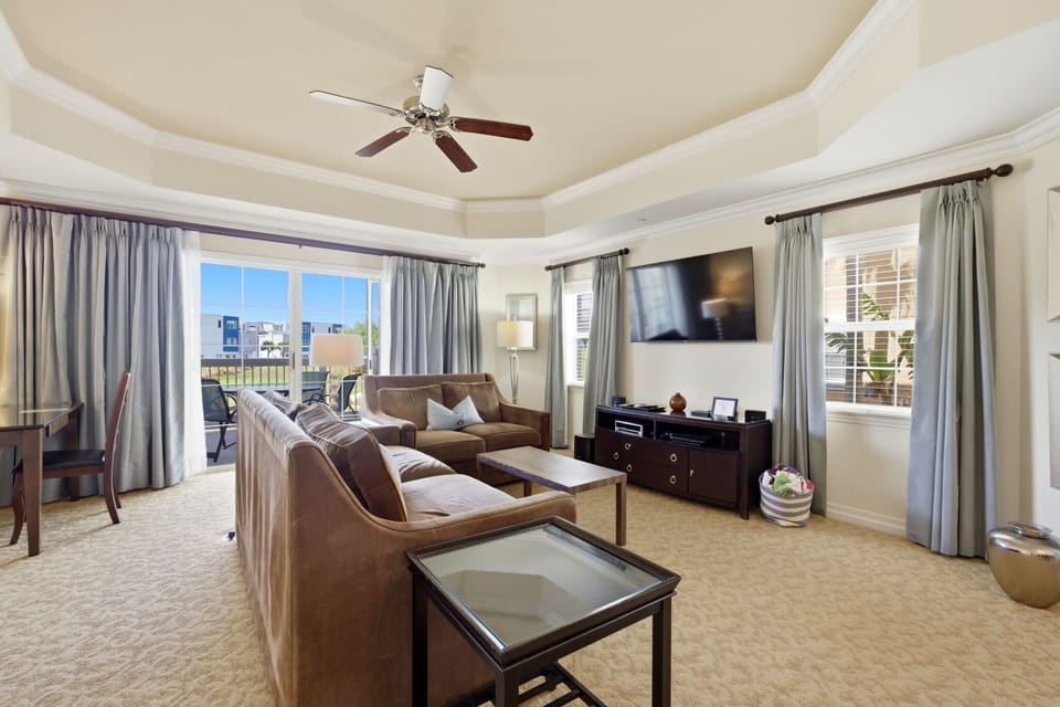 Light-filled living room with plush seating and large smart TV—your go-to spot to unwind after a day at Disney