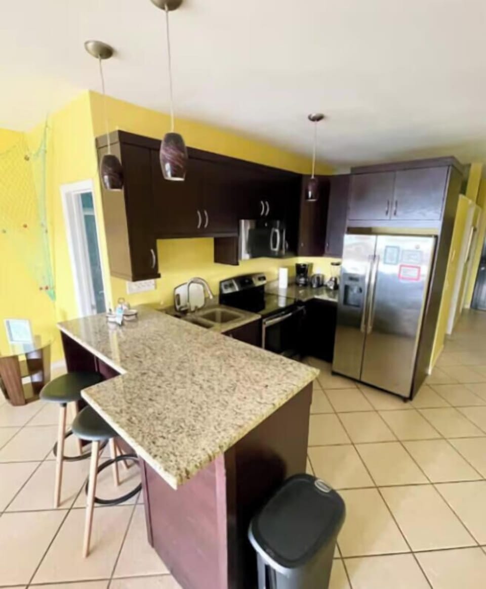 Kitchen with counter dining and coffee maker, microwave, blender, toaster
