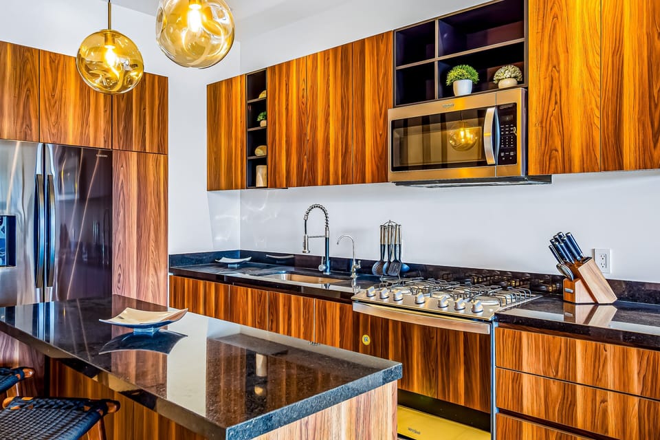 Cook and gather in this beautifully designed kitchen featuring sleek finishes, premium appliances, a breakfast bar, and an open layout that flows seamlessly into the dining and living areas.