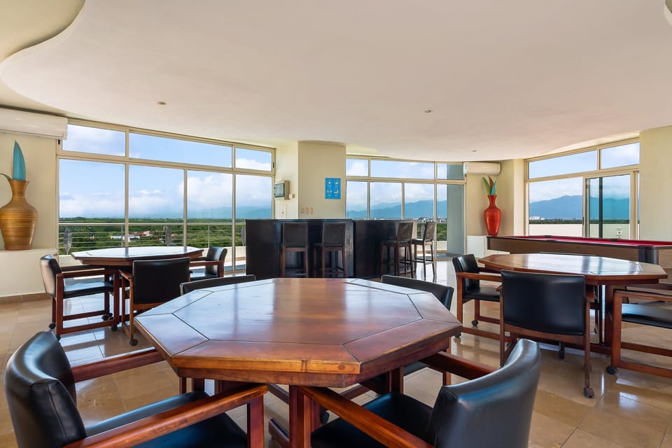 Gather for games, cocktails, and conversation in this spacious rooftop lounge featuring card tables, a pool table, and panoramic mountain views. A perfect setting for relaxing and connecting with family and friends.