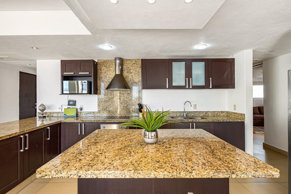 Sleek and spacious kitchen with granite countertops, stainless steel appliances, and a large island perfect for prepping or gathering.