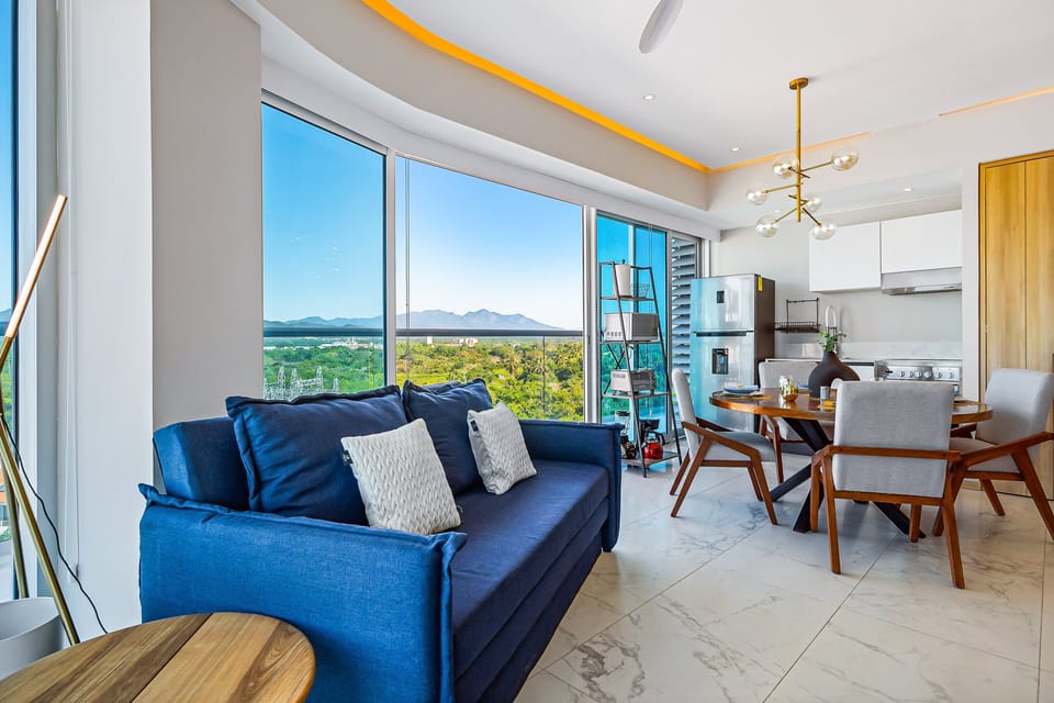 Relax in a stylish open-concept living area with floor-to-ceiling windows, modern furnishings, and beautiful views stretching to the horizon.