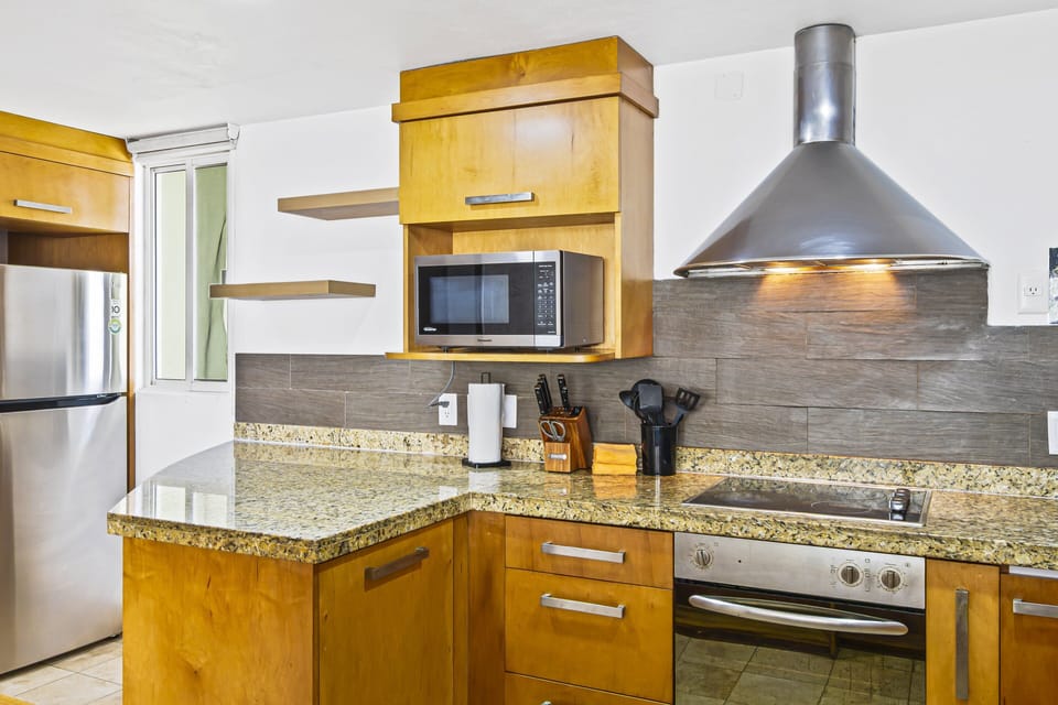 Modern kitchen with granite countertops, stainless appliances, and all essentials for easy meal preparation.
