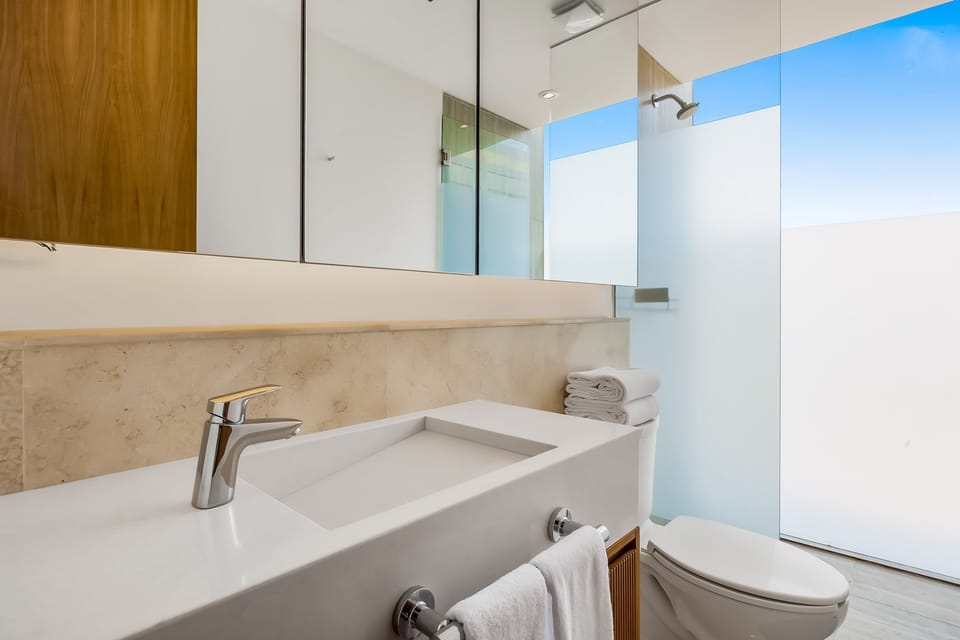 Refresh in a bright, modern bathroom featuring elegant finishes, a spacious walk-in shower, and premium amenities.