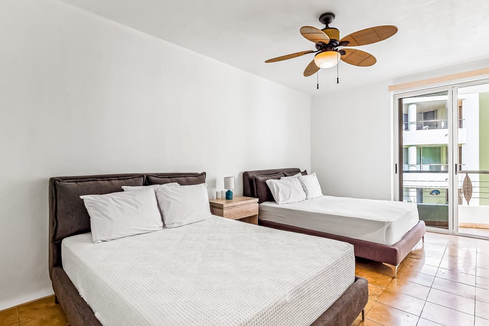 Guest room featuring two beds and private balcony access for fresh tropical breezes. Comfortable Nuevo Vallarta condo perfect for group getaways.