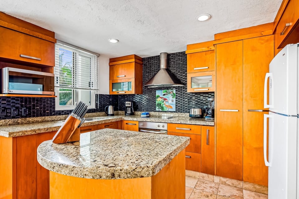 Fully equipped kitchen with granite counters, island workspace, and modern appliances. Enjoy cooking in your Nuevo Vallarta vacation home near Puerto Vallarta.