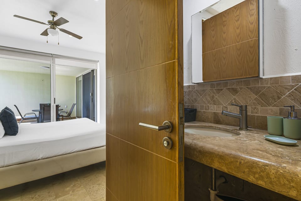 Freshen up in the stylish bathroom vanity space featuring modern finishes, stone countertops, and plenty of natural light.